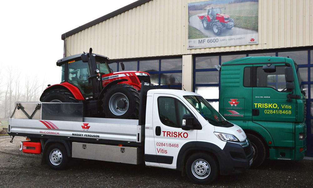 unser kleinerer Abschlepptransporter mit einem roten Traktor auf der Ladefläche